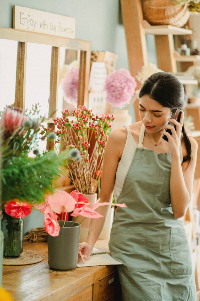 woman florist on call taking order - local seo for small businesses